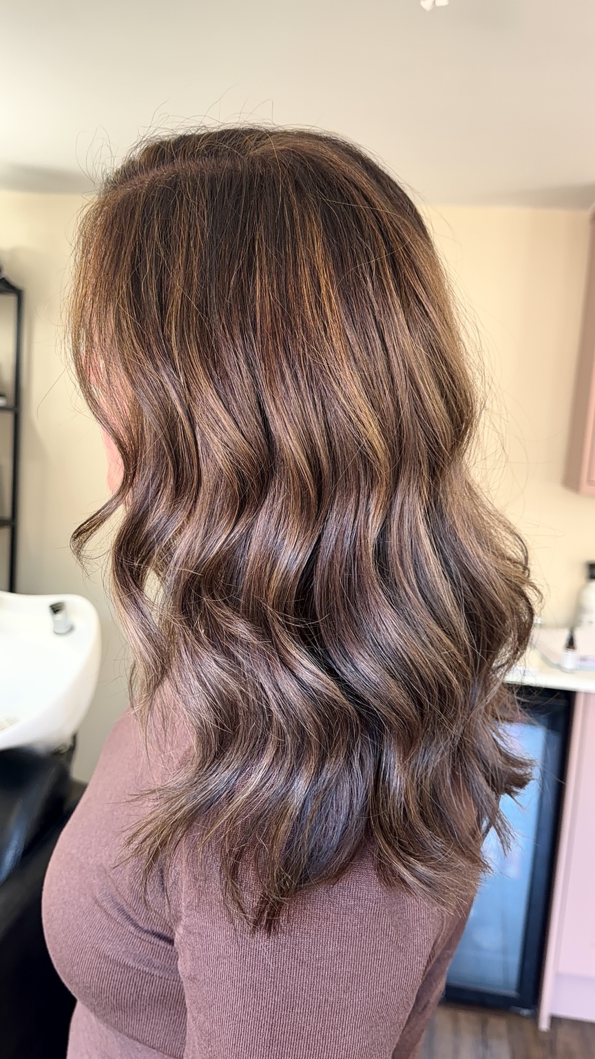 Dimensional brunette colour with soft warm highlights and waves by Selina at The Room
